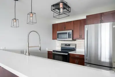 a kitchen with wooden cabinets and a stainless steel refrigerator at The Blue - Walk to the Village Shuttle & Hot Tub in Blue Mountains