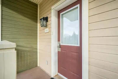 a red door on the side of a house at The Blue - Walk to the Village Shuttle & Hot Tub in Blue Mountains