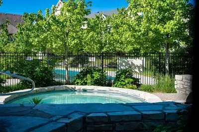 a small pool in front of a fence with trees at Sunny Days - Steps to Blue Mtn - Hot Tub & Shuttle in Blue Mountains