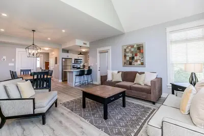 a living room with a couch and a table at Sunny Days - Steps to Blue Mtn - Hot Tub & Shuttle in Blue Mountains