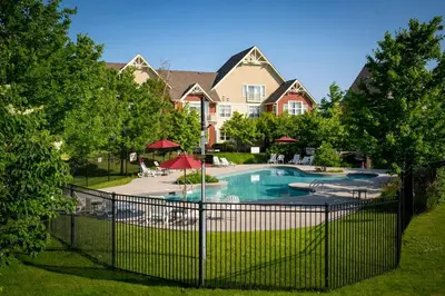 a fence in front of a house with a swimming pool at Sunny Days - Steps to Blue Mtn - Hot Tub & Shuttle in Blue Mountains