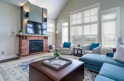 a living room with a couch and a fireplace at Bears Den - Hot Tub - Ski Views - Walk to Village in Blue Mountains
