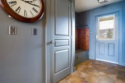 a clock hanging on a wall next to a door at Bears Den - Hot Tub - Ski Views - Walk to Village in Blue Mountains