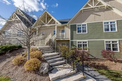 a green house with stairs in front of it at Raccoon Ridge - Village Walk - Hot Tub - Shuttle in Blue Mountains