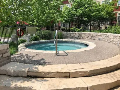 a small pool with a fountain in a stone wall at Raccoon Ridge - Village Walk - Hot Tub - Shuttle in Blue Mountains