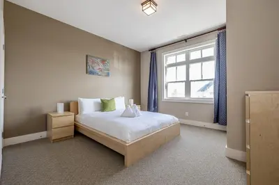 a bedroom with a large bed and a window at Raccoon Ridge - Village Walk - Hot Tub - Shuttle in Blue Mountains