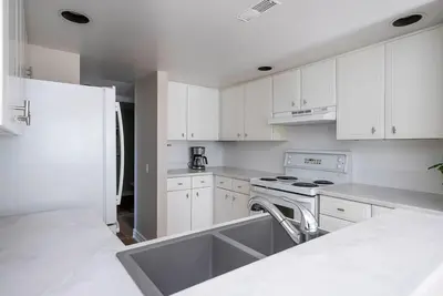 a kitchen with white cabinets and a stove top oven at Sierra Point - Walk to the Blue - Outdoor Pool in Blue Mountains