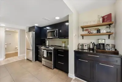 a kitchen with black cabinets and stainless steel appliances at Sierra Peaks - Village and Golf retreat in Blue Mountains