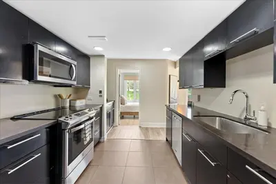 a kitchen with black cabinets and stainless steel appliances at Sierra Peaks - Village and Golf retreat in Blue Mountains