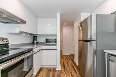 a kitchen with white cabinets and a stainless steel refrigerator at Sierra Summit - Walk to the Village family fun in Blue Mountains