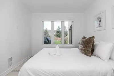 a white bed in a white room with a window at Sierra Summit - Walk to the Village family fun in Blue Mountains