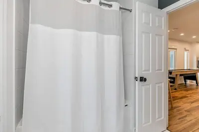 a white shower curtain in a room with a table at Sierra Summit - Walk to the Village family fun in Blue Mountains