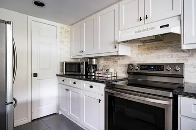 a kitchen with white cabinets and a stove top oven at Sierra Views - Steps to Blue Mountain Village in Blue Mountains
