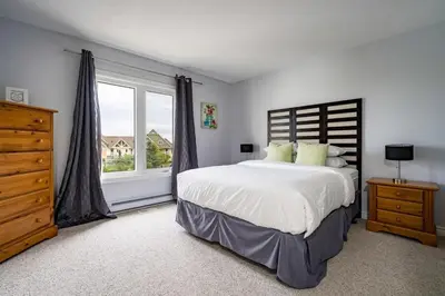 a bedroom with a large bed and a window at Sierra Views - Steps to Blue Mountain Village in Blue Mountains