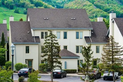 a large white house with cars parked in a parking lot at Sierra Views - Steps to Blue Mountain Village in Blue Mountains