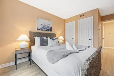 a bedroom with a large white bed and a night stand at Sierra Heights - Steps to Blue Mountain Village in Blue Mountains