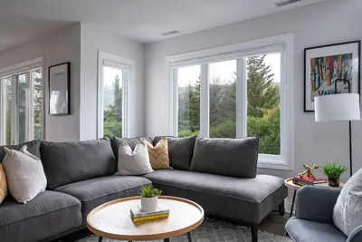a living room with a couch and two windows at Sierra Lookout - Steps to Blue Mountain Village in Blue Mountains