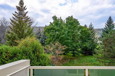 a view of trees from a porch with a fence at Sierra Lookout - Steps to Blue Mountain Village in Blue Mountains