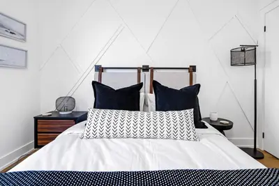 a bedroom with a white bed with blue and white pillows at View to Blue - Walk to the Village Mountain Views in Blue Mountains