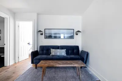 a living room with a blue couch and a coffee table at View to Blue - Walk to the Village Mountain Views in Blue Mountains