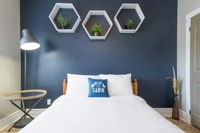 a blue bedroom with a bed with four plants on the wall at Hidden Haven - Shuttle to Blue - Private Patio in Blue Mountains