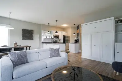 a living room with a couch and a kitchen at Hidden Haven - Shuttle to Blue - Private Patio in Blue Mountains