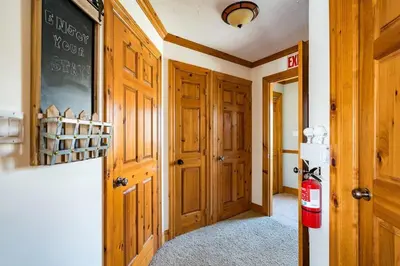a hallway with wooden doors and a refrigerator in a house at Out of the Blue - Shuttle to Blue Walk & Trails in Blue Mountains