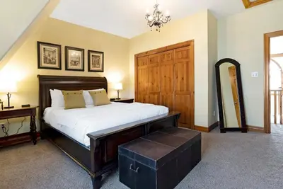 a bedroom with a large bed with a wooden door at Out of the Blue - Shuttle to Blue Walk & Trails in Blue Mountains