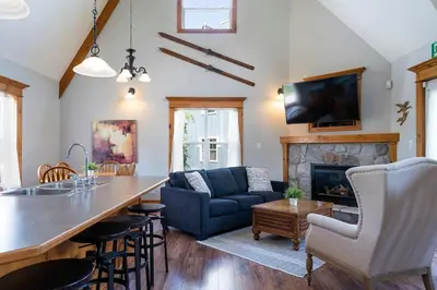 a living room with a kitchen and a fireplace at Still Winds - Private Patio - Shuttle to Blue in Blue Mountains