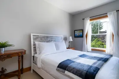 a bedroom with a large bed and a window at Still Winds - Private Patio - Shuttle to Blue in Blue Mountains