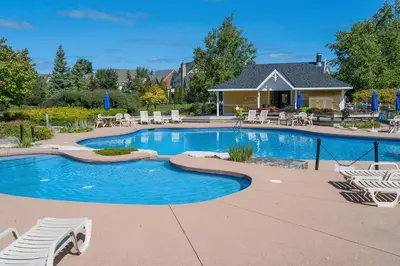a swimming pool with chairs and a house at Still Winds - Private Patio - Shuttle to Blue in Blue Mountains
