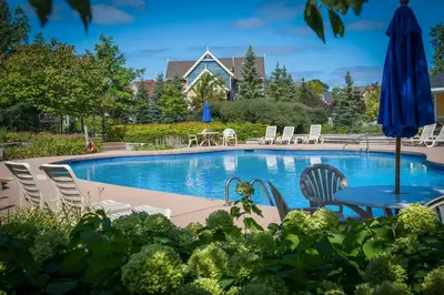 a pool with chairs and a table and an umbrella at Still Winds - Private Patio - Shuttle to Blue in Blue Mountains