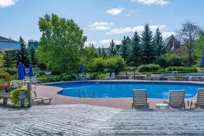 a large swimming pool with chairs and umbrellas at Still Winds - Private Patio - Shuttle to Blue in Blue Mountains