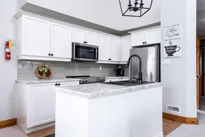 a white kitchen with a sink and a refrigerator at Snowy Mountain Summit & Sol - Shuttle - Patio in Blue Mountains