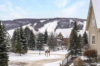 a town in the snow with trees and a church at Lookout Lodge - Private Patio - Shuttle to Blue in Blue Mountains