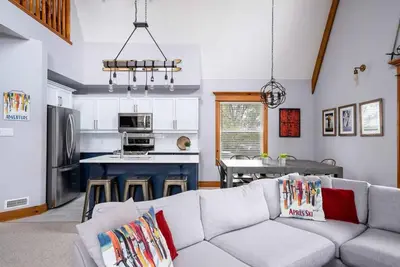 a living room with a couch and a kitchen at Lookout Lodge - Private Patio - Shuttle to Blue in Blue Mountains