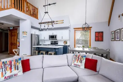 a living room with a white couch with red pillows at Lookout Lodge - Private Patio - Shuttle to Blue in Blue Mountains