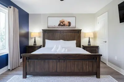 a bedroom with a bed with a wooden headboard at Luxury Mountain Townhome - Shuttle Patio & Trails in Blue Mountains