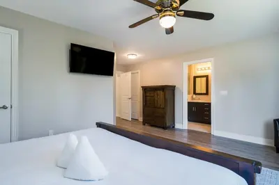 a bedroom with a white bed and a ceiling fan at Luxury Mountain Townhome - Shuttle Patio & Trails in Blue Mountains