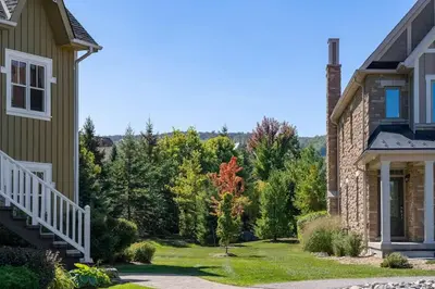 a house with a yard with trees in the background at Luxury Mountain Townhome - Shuttle Patio & Trails in Blue Mountains