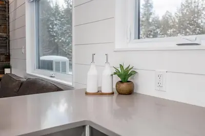 a kitchen counter with two white bottles on it at The Hideaway - Tiny House in Flesherton