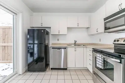 a kitchen with white cabinets and a stainless steel refrigerator at Snow Pine - 10 minute drive to Blue in Collingwood