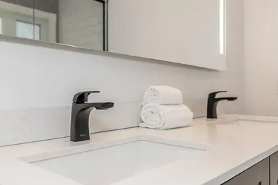 a bathroom sink with two towels and a mirror at Snow Pine - 10 minute drive to Blue in Collingwood