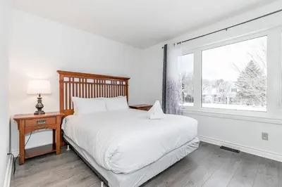a white bedroom with a bed and a window at Snow Pine - 10 minute drive to Blue in Collingwood