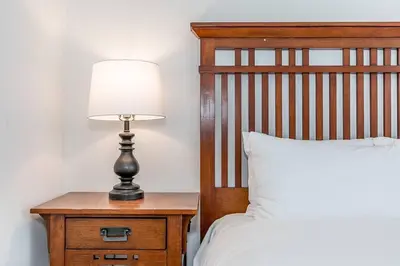 a lamp on a night stand next to a bed at Snow Pine - 10 minute drive to Blue in Collingwood