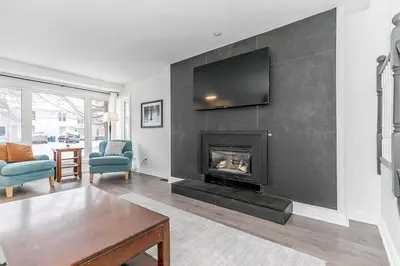a living room with a fireplace with a tv on a wall at Snow Pine - 10 minute drive to Blue in Collingwood