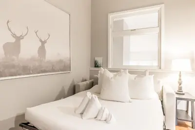a white bedroom with a bed with white pillows at Memory Lane - Walk to the Village - Sleeps 10 in Blue Mountains