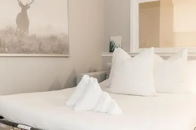 a bedroom with a white bed with white pillows at Memory Lane - Walk to the Village - Sleeps 10 in Blue Mountains