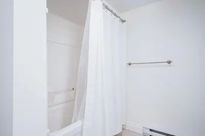 a white shower curtain in a white bathroom at The Mountain House - Walk to the Village in Blue Mountains