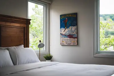 a bedroom with a bed and a poster on the wall at Apres-Blu - Walk to theVillage - Sleeps 7 in Blue Mountains